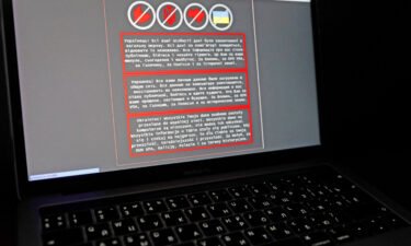 A laptop screen displays a warning message in Ukrainian