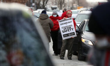 Teacher Stuart Abram holds a sign in support of the Chicago Teachers Union before a CTU caravan on January 5