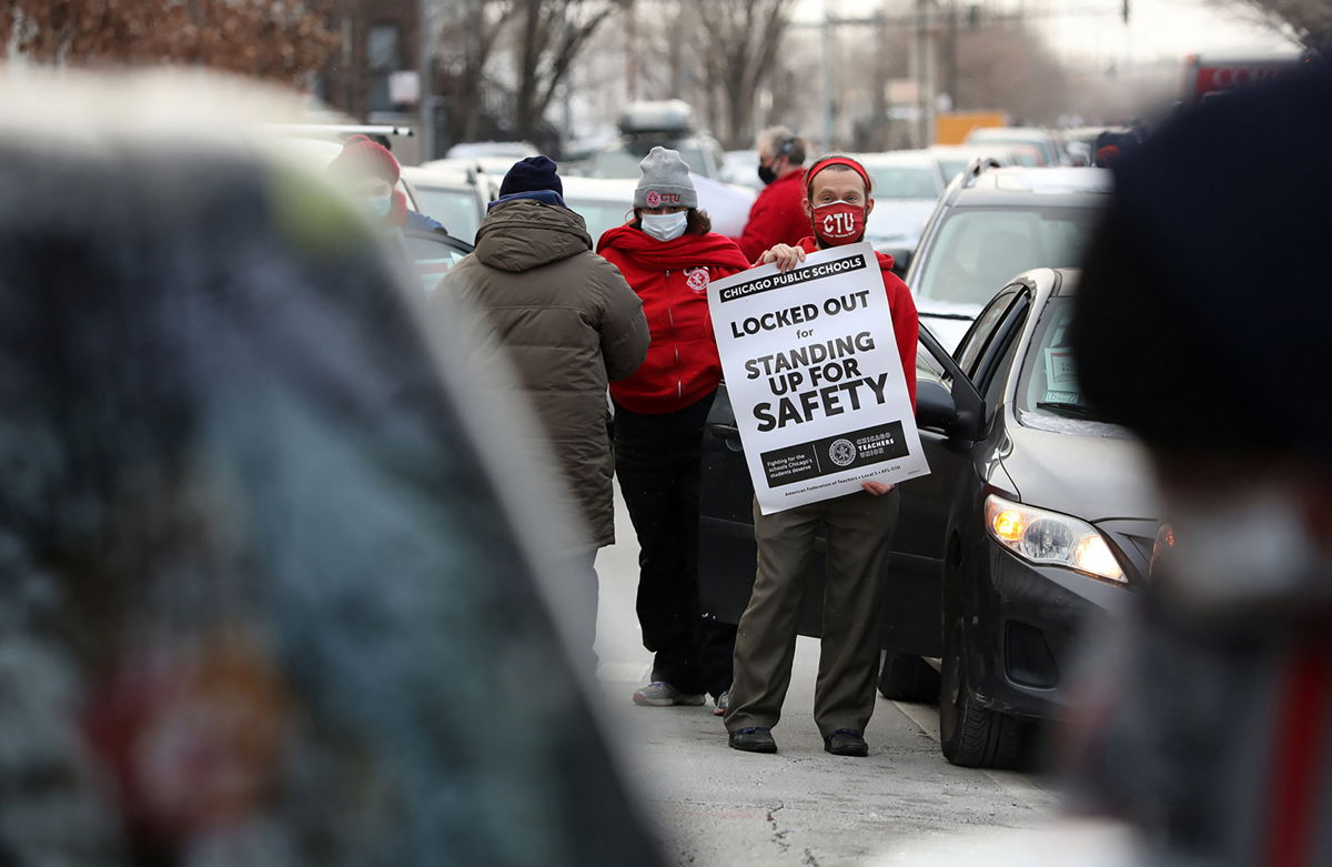 <i>John J. Kim/Chicago Tribune/Tribune News Service/Getty Images</i><br/>Teacher Stuart Abram holds a sign in support of the Chicago Teachers Union before a CTU caravan on January 5