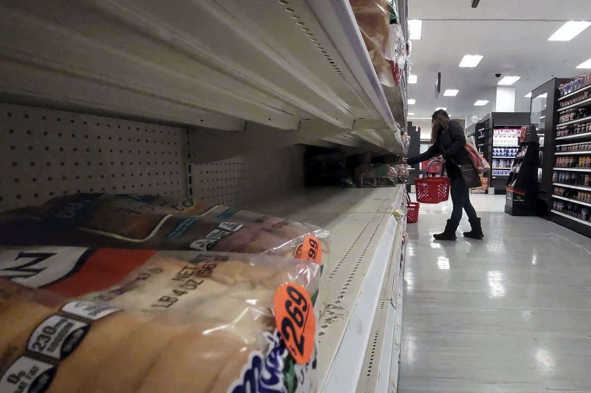 <i>Anthony Behar/Sipa USA/AP</i><br/>A shopper walks past partially empty bread shelves at a Target store in the Queens borough of New York City