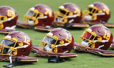 Team football helmets are lined up before practice during the Washington Football Team's training camp.