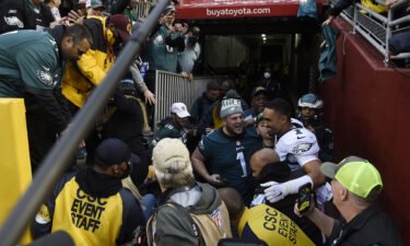 Jalen Hurts #1 of the Philadelphia Eagles celebrates with fans who fell onto the ground after a railing collapsed following the win over the Washington Football Team 20-16 at FedExField on January 2