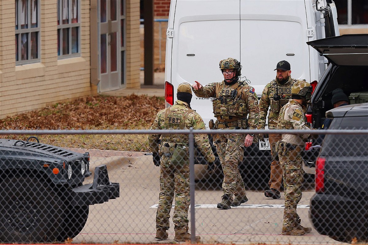 <i>Andy Jacobsohn/AFP/Getty Images</i><br/>SWAT team members deploy near the Congregation Beth Israel Synagogue in Colleyville