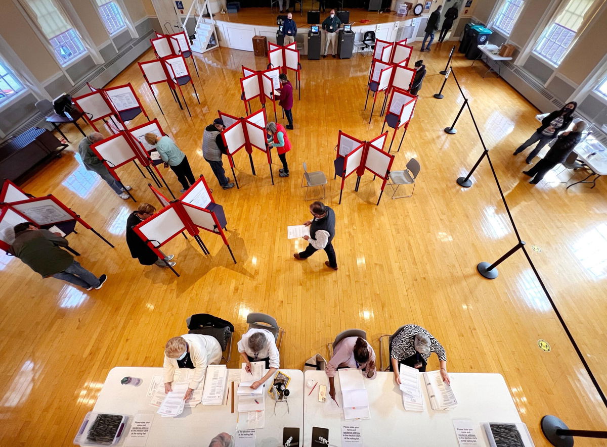 <i>Gregory Rec/Portland Press Herald/Getty Images</i><br/>Election workers check in people as voters cast their ballots in Kennebunk