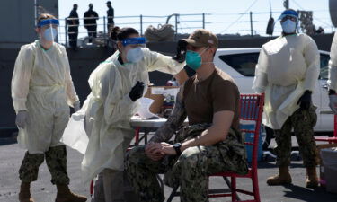 A United States Navy officer from the amphibious ship USS San Diego receives a Covid-19 vaccine at the Navy port in Manama