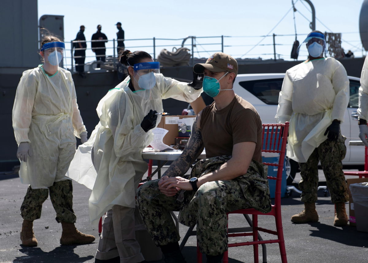 <i>Brandon Woods/U.S. Navy/Handout/Reuters</i><br/>A United States Navy officer from the amphibious ship USS San Diego receives a Covid-19 vaccine at the Navy port in Manama