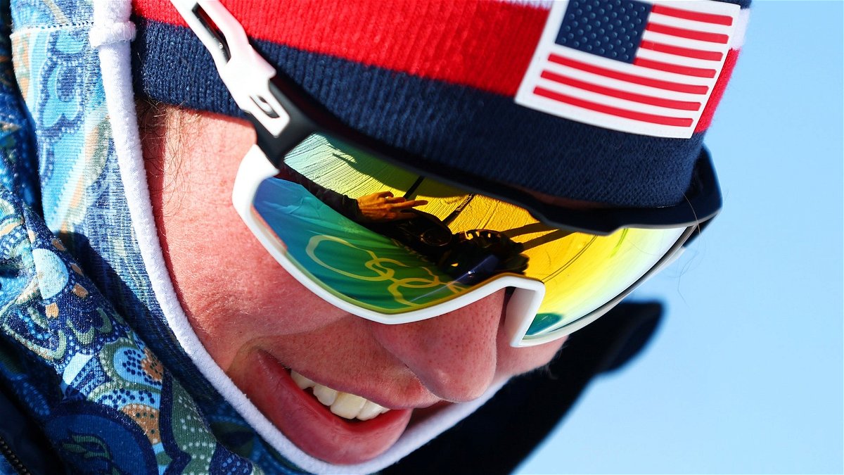 Cross-country skier Caitlin Patterson looking down smiling with sunglasses on at training day