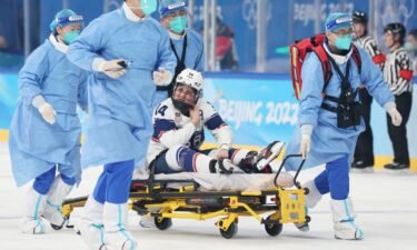 An injured Brianna Decker is stretchered off against Finland.
