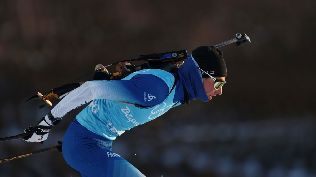 French biathlete with rifle on back skis during a training session