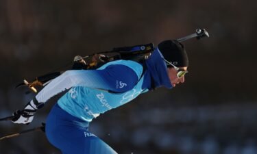 French biathlete with rifle on back skis during a training session