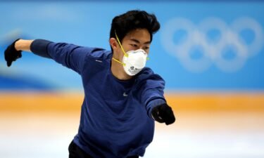 Nathan Chen skates in blue shirt and mask