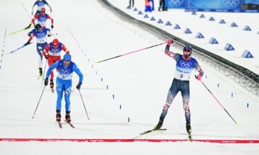 Johannes Hoesflot Klaebo (R) of Team Norway celebrates winning the Gold medal and Federico Pellegrino of Team Italy celebrates winning the Silver medal as they cross the finish line during the Men's Cross-Country Sprint Free Final