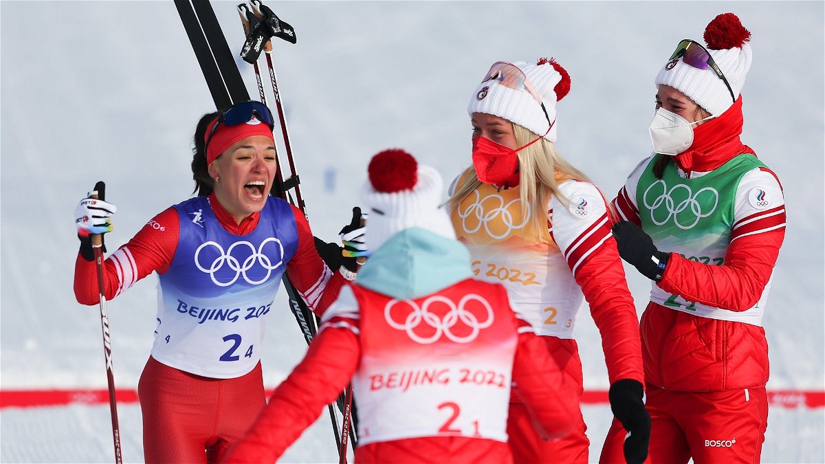 Veronika Stepanova (L) of Team ROC celebrates with teammates after winning the gold medal during the Women's Cross-Country 4x5km Relay