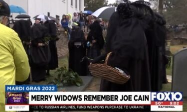 The Merry Widows surround he grave of Joe Cain