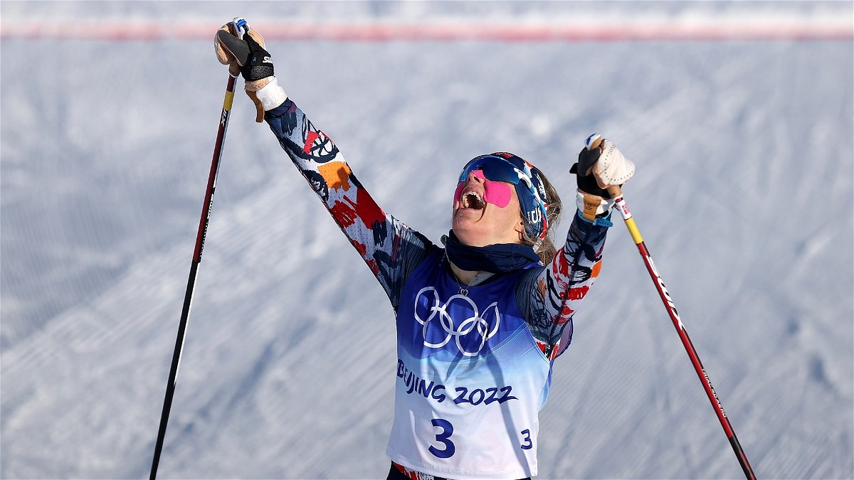 Norway's Therese Johaug with hands in the air after winning gold in the women's skiathlon