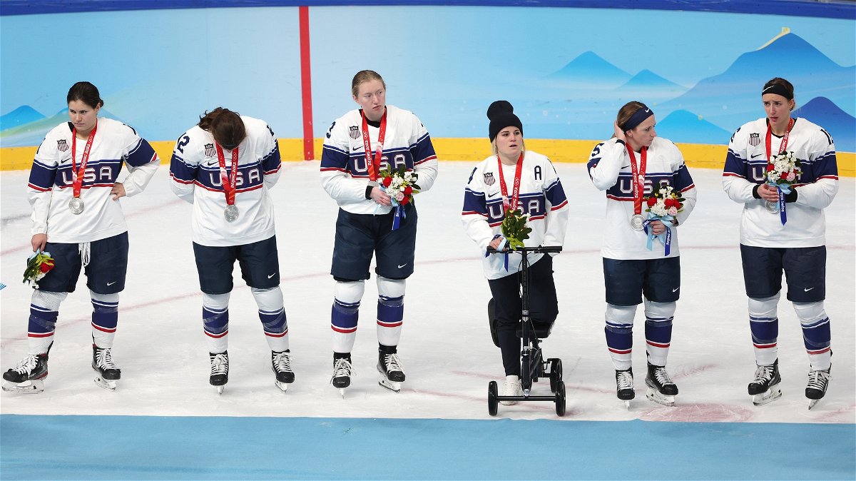 Team USA receives silver medals with injured player Brianna Decker after the women's ice hockey gold medal game loss to Team Canada