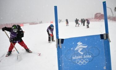 Crew members prepare the course as snow falls ahead of the first run of the men's giant slalom during the 2022 Winter Olympic Games at the Yanqing National Alpine Skiing Center.
