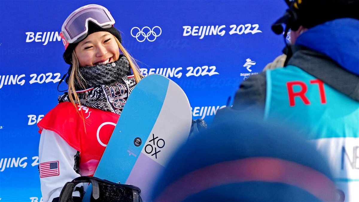 Chloe Kim smiling with her snowboard