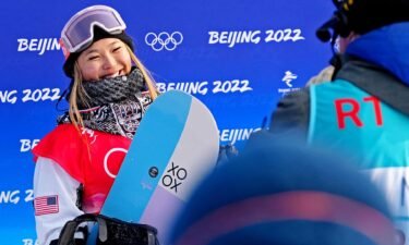 Chloe Kim smiling with her snowboard