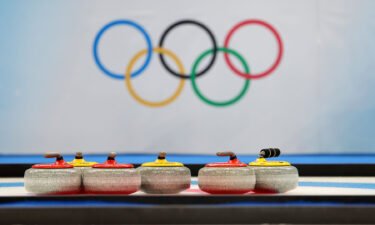 Curling stones in front of the Olympic rings