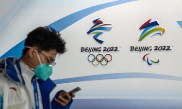 A man walks past Winter Olympics and Paralympics branding at the Main Press Centre on January 26 in Beijing