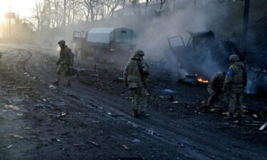 Ukrainian service members collect unexploded shells after a fighting with Russian raiding group in the Ukrainian capital of Kyiv in the morning of February 26