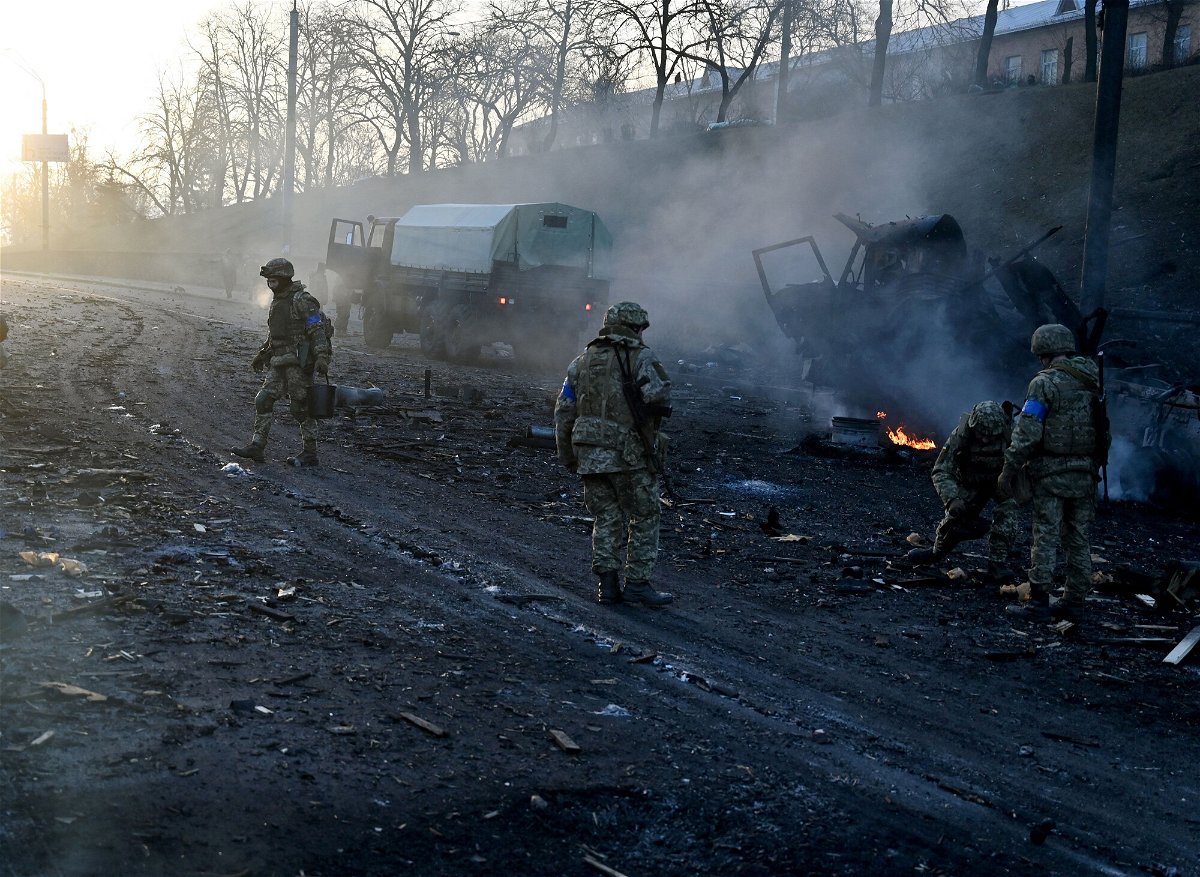 <i>Sergei Supinsky/AFP/Getty Images</i><br/>Ukrainian service members collect unexploded shells after a fighting with Russian raiding group in the Ukrainian capital of Kyiv in the morning of February 26