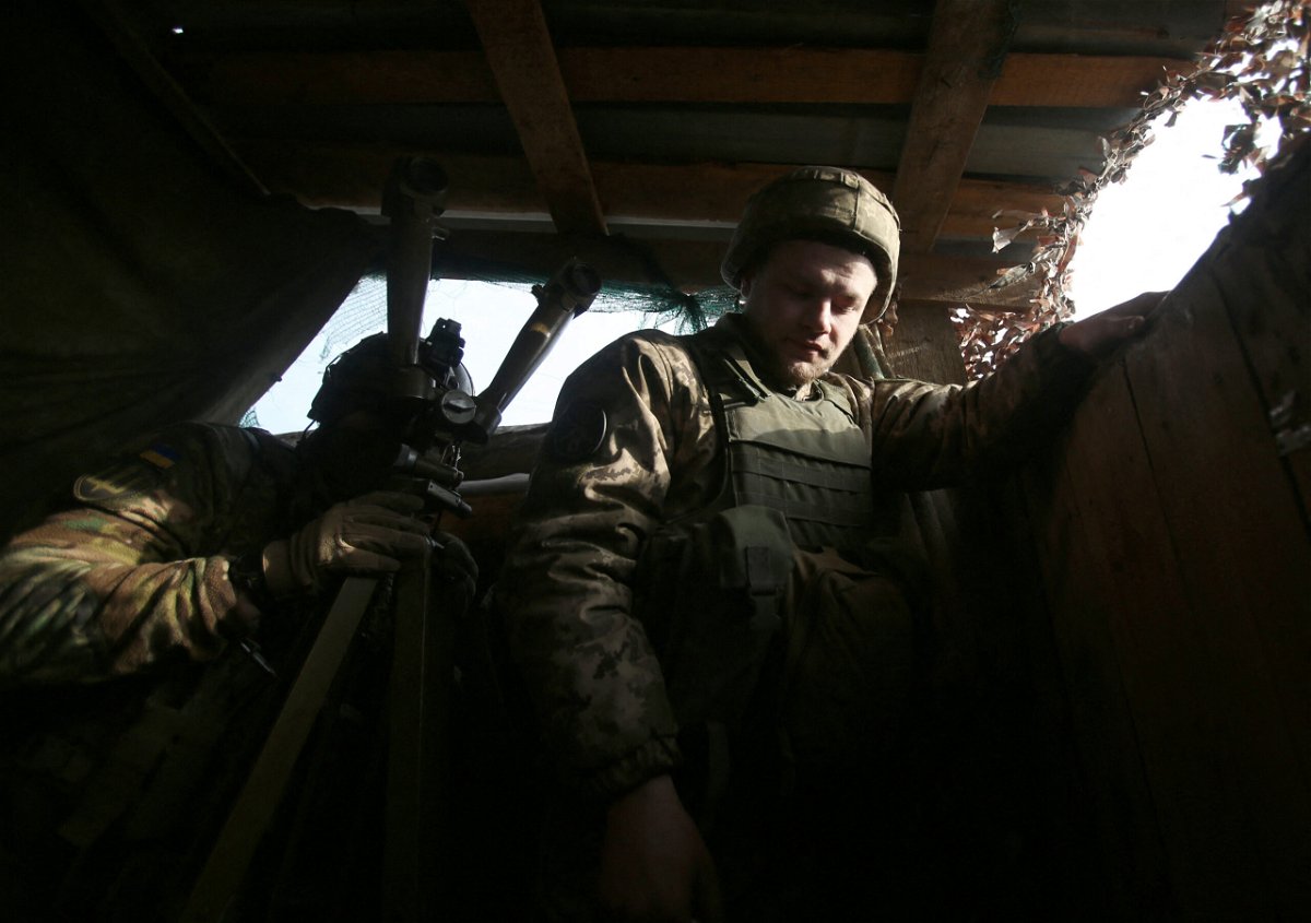 <i>ANATOLII STEPANOV/AFP/AFP via Getty Images</i><br/>A Ukrainian serviceman looks through a spyglass on the front line with Russia-backed separatists