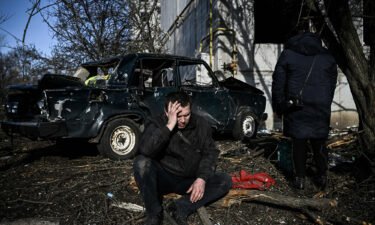 A man sits outside his destroyed building after bombings on the eastern Ukraine town of Chuguiv on February 24.