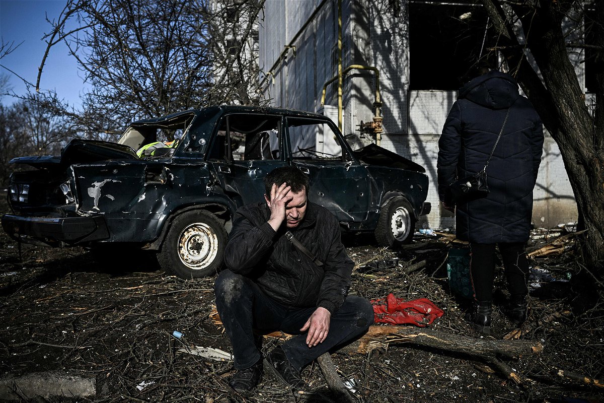 <i>Aris Messinis/AFP/Getty Images</i><br/>A man sits outside his destroyed building after bombings on the eastern Ukraine town of Chuguiv on February 24.