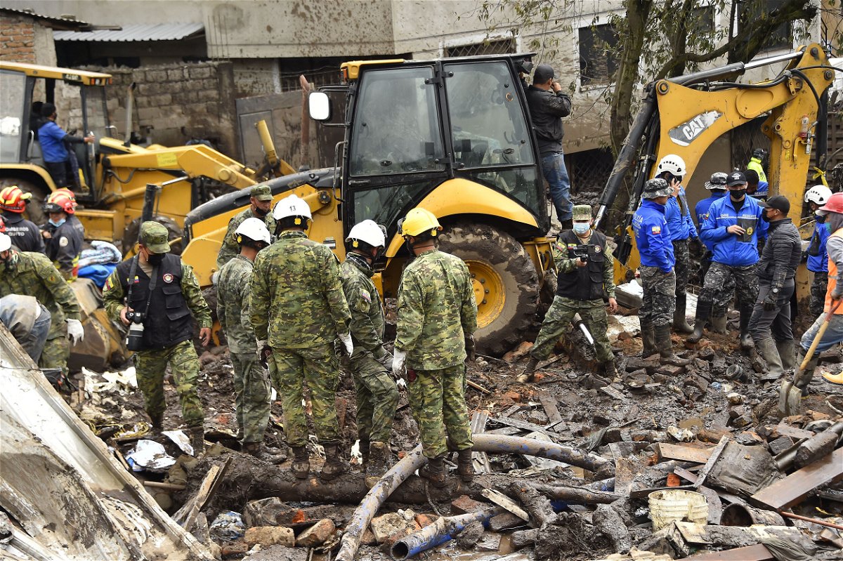 <i>Rodrigo Buendia/AFP/Getty Images</i><br/>Rescue workers search for survivors after torrential rains triggered a landslide in Quito