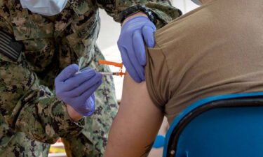 A hospital corpsman administers a Covid-19 vaccine aboard Naval Station Norfolk