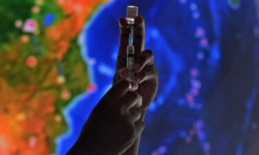 A health worker poses with a syringe with dose of a COVID-19 vaccine at the Museum of Tomorrow where adults and children between the ages of five and eleven are being vaccinated against the novel coronavirus