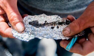 A man holds a piece of foil containing Fentanyl while spending time on in San Francisco