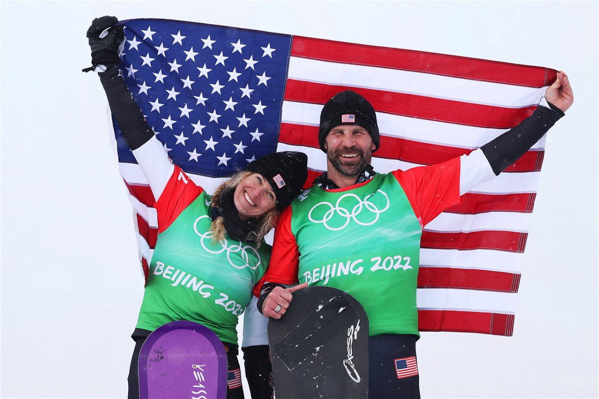 <i>Cameron Spencer/Getty Images</i><br/>Gold medalists Lindsey Jacobellis and Nick Baumgartner of Team United States celebrate during the mixed team snowboard cross flower ceremony on Day 8 of the Beijing 2022 Winter Olympics on February 12.