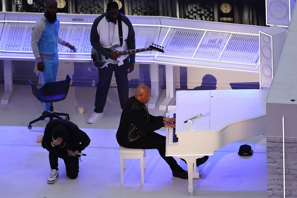 <i>Gregory Shamus/Getty Images</i><br/>Eminem kneels next to Dr. Dre during the Pepsi Super Bowl LVI Halftime Show at SoFi Stadium on February 13