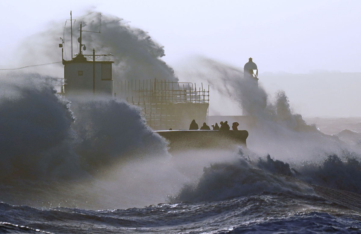 <i>Jacob King/PA Images/Getty Images</i><br/>Waves crash against the sea wall and Porthcawl Lighthouse in Bridgend