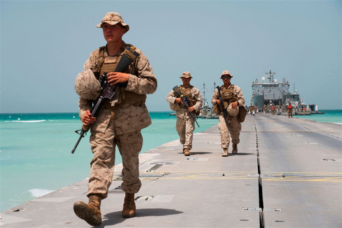 <i>Jon Gambrell/AP</i><br/>US Marines walk to an American ship docked near a military base in the UAE during a March 2020 exercise.