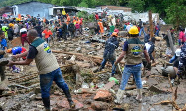Neighbors join rescue workers in the hunt for survivors after a rain-weakened hillside collapsed over homes in Pereira