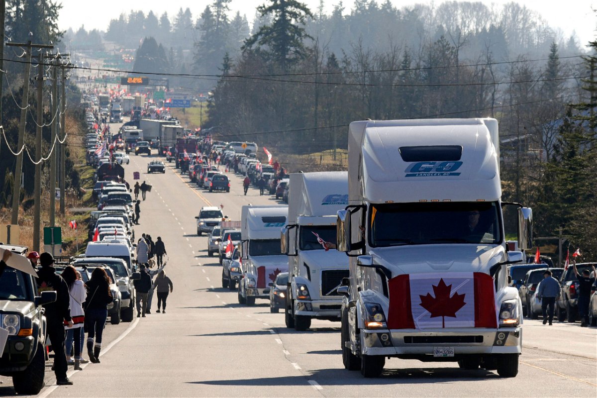 <i>Jason Redmond/AFP/Getty Images</i><br/>Trucks with Canadian flags drive by anti-vaccine mandate and anti-government protesters Saturday in Surrey
