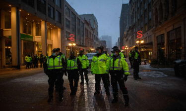 Police officers gather on a street during a protest over pandemic health rules outside the parliament of Canada in Ottawa on February 17.
