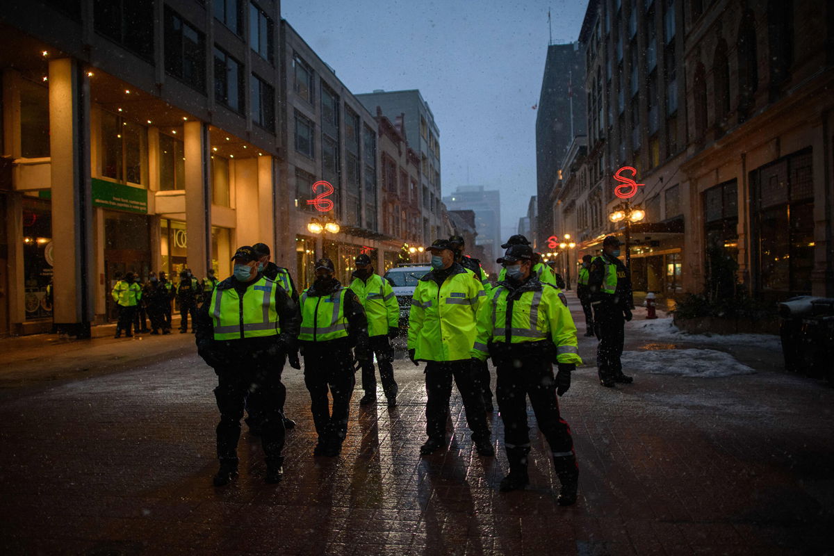 <i>Ed Jones/AFP/Getty Images</i><br/>Police officers gather on a street during a protest over pandemic health rules outside the parliament of Canada in Ottawa on February 17.
