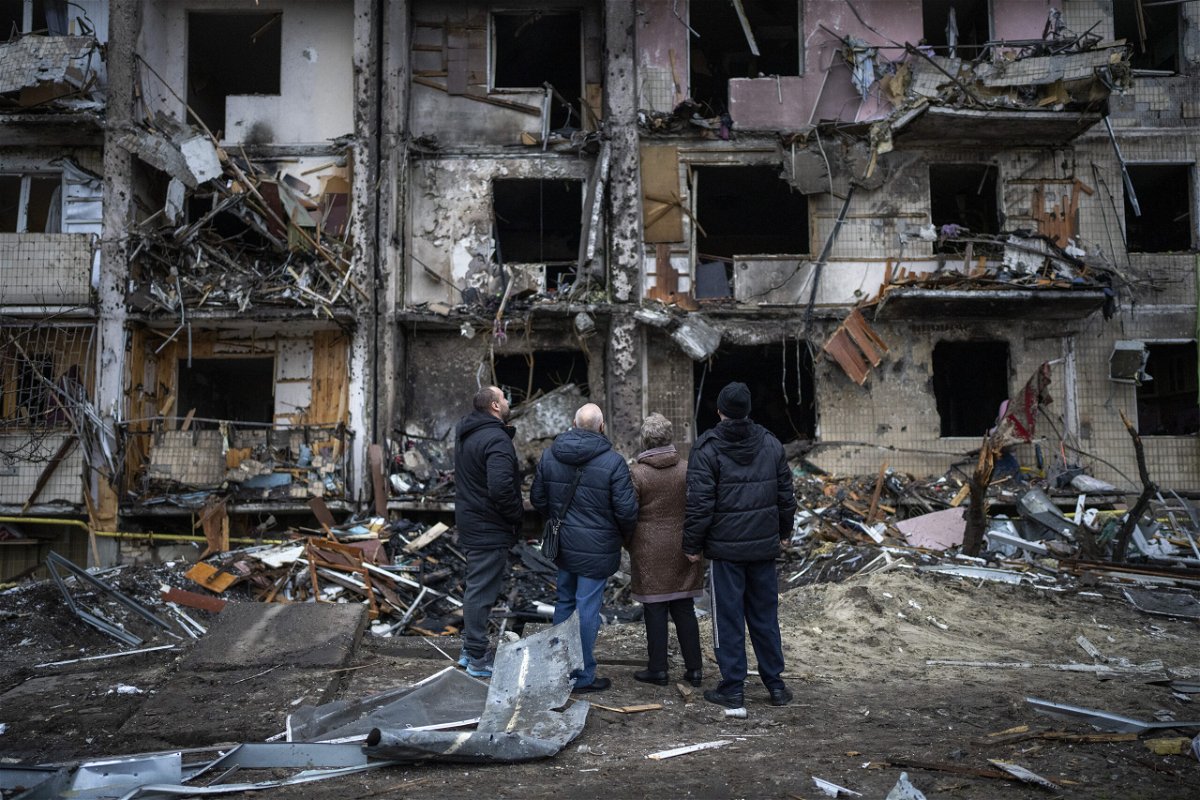 <i>Emilio Morenatti/AP</i><br/>People look at damage following an attack on the city of Kyiv