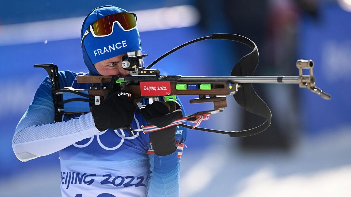 Justine Braisaz-Bouchet in blue shoots biathlon from standing position