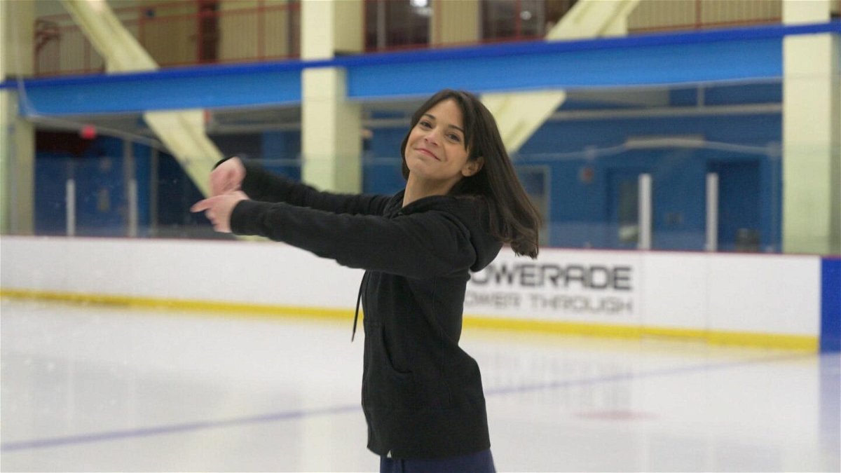 Katie Nolan on ice with hands in the air