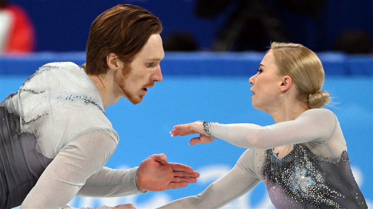 Vladimir Morozov (left) and Yevgenia Tarasova (right) look at each other while skating