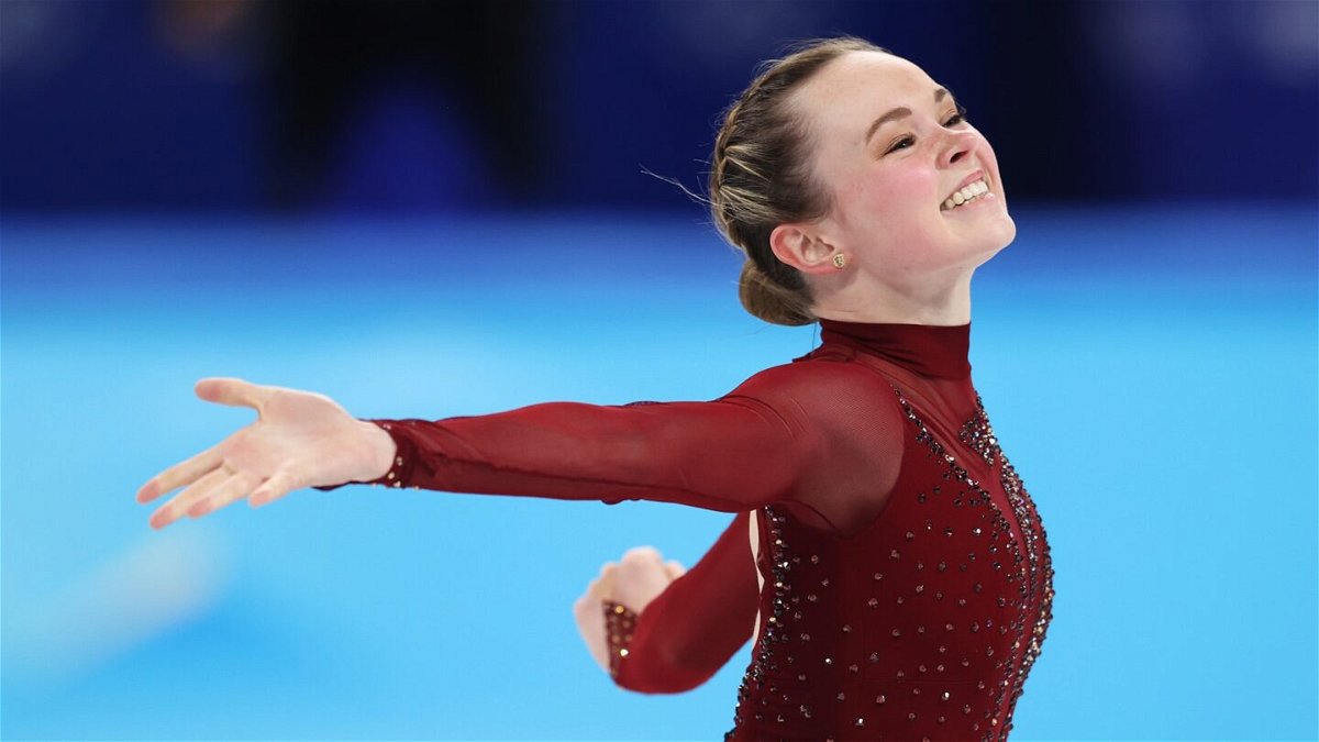 Mariah Bell skates in red costume with arms out