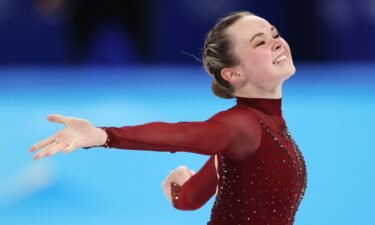 Mariah Bell skates in red costume with arms out