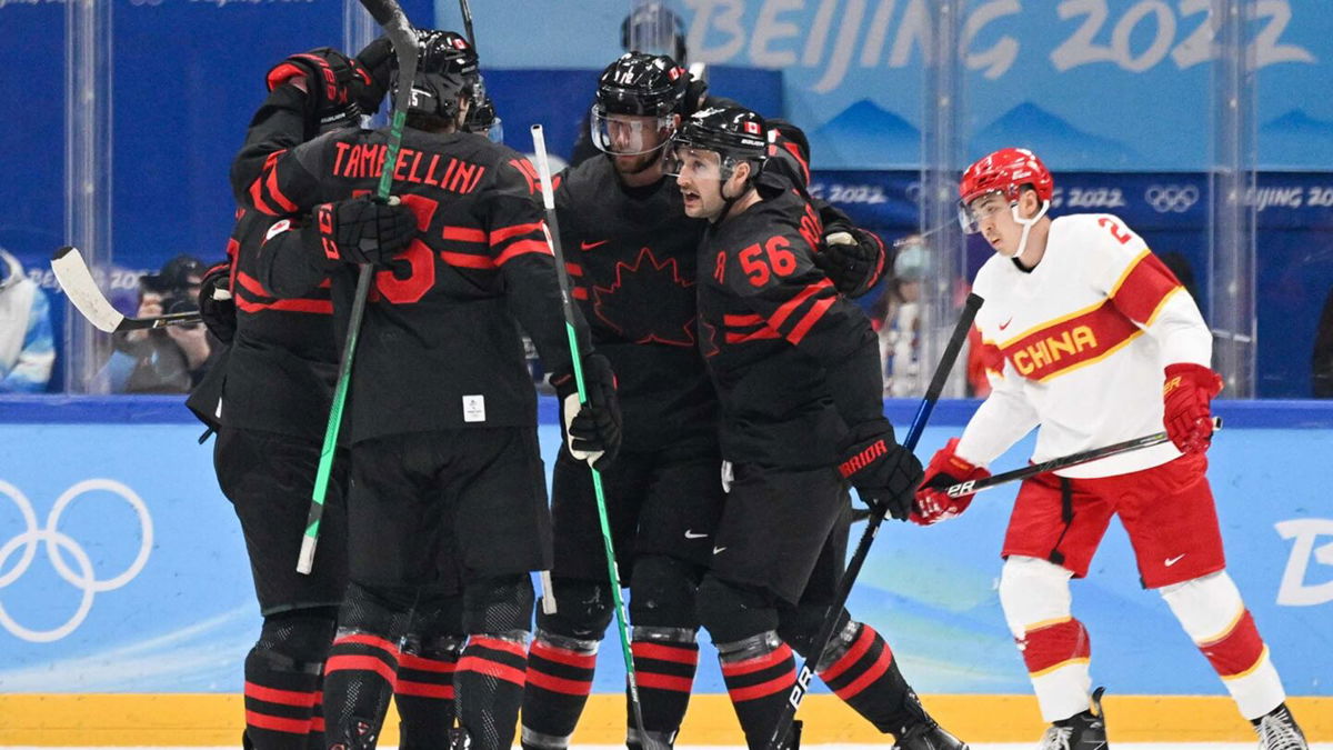 Canadian men's hockey team celebrates together on the ice