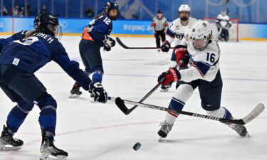 Finnish and U.S. women's hockey players fight for the puck